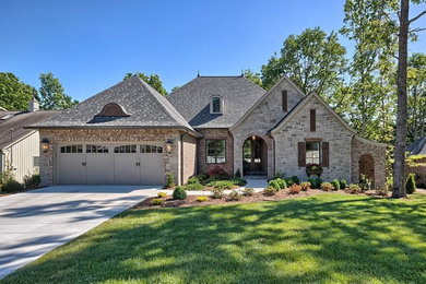 Large transitional brown two-story brick exterior home photo in Other