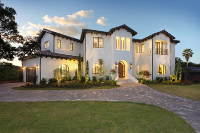 Mid-sized mediterranean white two-story stucco exterior home idea in Tampa with a tile roof