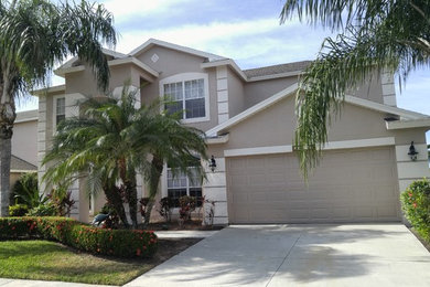 Photo of a medium sized and gey traditional two floor house exterior in Miami with stone cladding and a pitched roof.