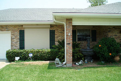 Example of a large one-story brick exterior home design in New Orleans