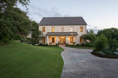 Photo of a large and beige contemporary two floor detached house in Austin with a pitched roof, a metal roof and stone cladding.