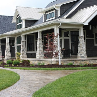 Imagen de fachada de casa gris, de estilo americano, grande, de dos plantas, con revestimiento de piedra y tejado de teja de madera
