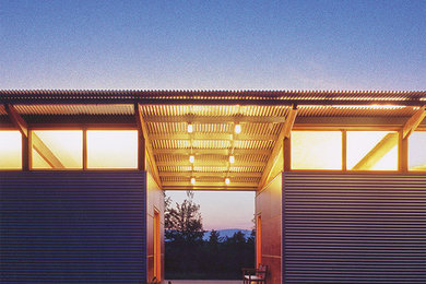 Diseño de fachada gris moderna pequeña de una planta con revestimiento de metal y tejado de un solo tendido