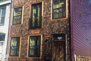 Imagen de fachada marrón tradicional renovada grande de tres plantas con revestimiento de madera