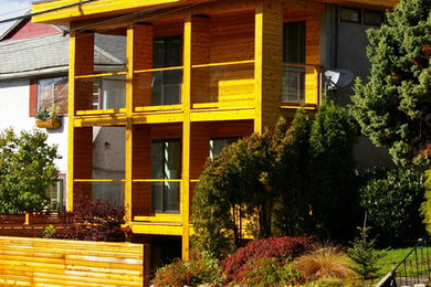 Diseño de fachada moderna de tamaño medio de tres plantas con revestimiento de madera