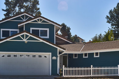 Cette photo montre une façade de maison bleue bord de mer en panneau de béton fibré de taille moyenne et de plain-pied avec un toit à deux pans.