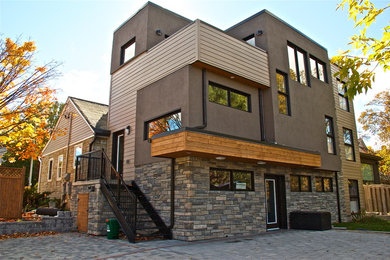 Ejemplo de fachada marrón minimalista de tamaño medio de tres plantas con revestimientos combinados y tejado plano