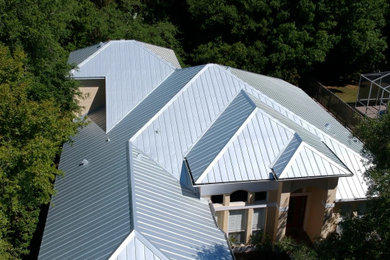 Diseño de fachada de casa de tamaño medio de una planta con tejado a dos aguas y tejado de metal
