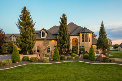 Inspiration for an expansive and beige traditional two floor render detached house in Boise with a half-hip roof and a shingle roof.
