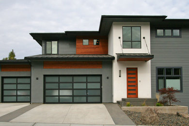 Ejemplo de fachada de casa gris contemporánea de tamaño medio de dos plantas con revestimientos combinados, tejado a cuatro aguas y tejado de varios materiales