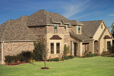 Large traditional brown two-story brick house exterior idea in Atlanta with a hip roof and a shingle roof