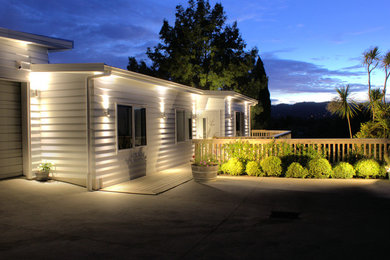 Modelo de fachada de casa blanca clásica de tamaño medio de una planta con revestimiento de madera, tejado plano y tejado de metal