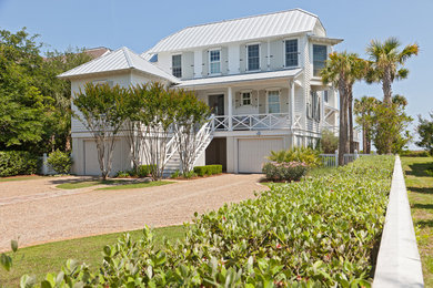 Beach style white three-story wood exterior home photo in Charleston with a hip roof