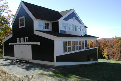 Inspiration pour une façade de maison verte traditionnelle en bois de taille moyenne et à un étage avec un toit à deux pans et un toit en shingle.