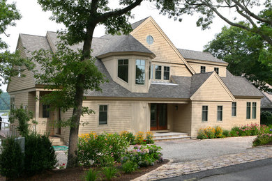 Diseño de fachada de casa beige tradicional grande de dos plantas con revestimiento de madera, tejado a dos aguas y tejado de teja de madera