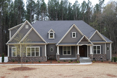 Foto de fachada de casa gris de estilo americano grande de dos plantas con revestimientos combinados, tejado a cuatro aguas y tejado de teja de madera