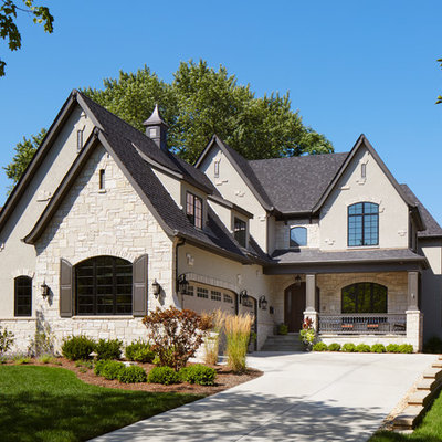 Example of a large arts and crafts beige three-story mixed siding gable roof design in Chicago
