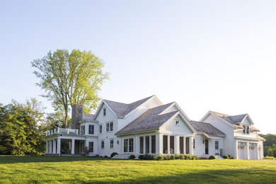 Huge transitional white three-story wood exterior home photo in New York with a shingle roof