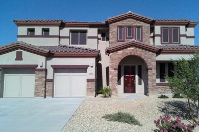 Mid-sized mediterranean white two-story stucco gable roof idea in Phoenix