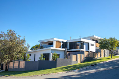 Modelo de fachada de casa blanca actual grande de dos plantas con revestimiento de aglomerado de cemento, tejado plano y tejado de metal