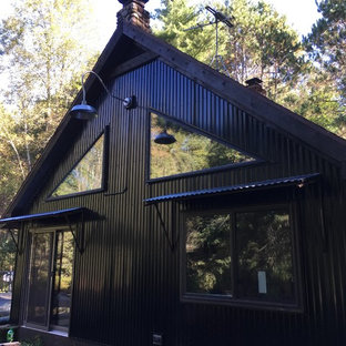 Modelo de fachada negra, bohemia, con revestimiento de metal y tejado a dos aguas