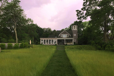 На фото: деревянный, коричневый частный загородный дом среднего размера в классическом стиле с мансардной крышей и крышей из гибкой черепицы