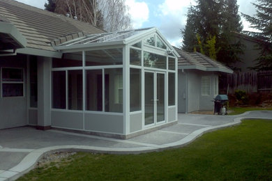 Foto de fachada gris de estilo americano de tamaño medio de una planta con revestimiento de estuco y tejado a cuatro aguas