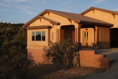 Diseño de fachada marrón de estilo americano de tamaño medio de una planta con revestimiento de estuco y tejado a dos aguas