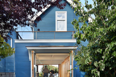 Small trendy blue two-story wood exterior home photo in Seattle with a shingle roof