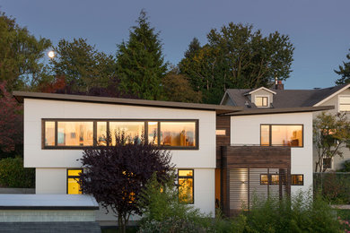 Example of a mid-sized trendy white two-story mixed siding exterior home design in Seattle with a shed roof