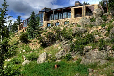 Huge mediterranean beige two-story stone exterior home idea in Denver with a hip roof