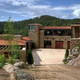Huge mountain style two-story stone exterior home photo in Denver