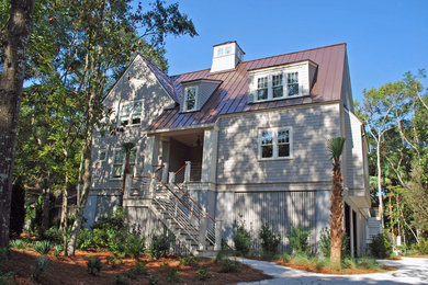 Immagine della facciata di una casa beige stile marinaro a due piani con tetto a capanna