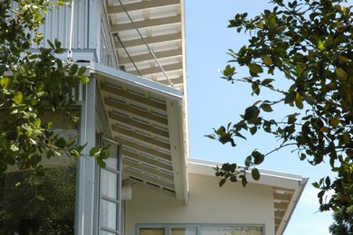 Example of a large eclectic beige two-story metal flat roof design in San Francisco