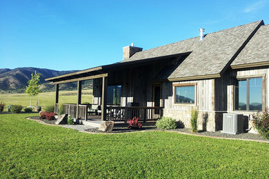 Diseño de fachada de casa gris rústica de tamaño medio de una planta con revestimiento de madera, tejado a dos aguas y tejado de varios materiales