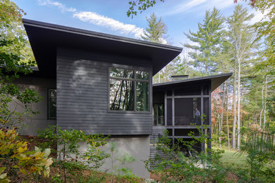 Inspiration for a mid-sized mid-century modern black two-story wood exterior home remodel in Other with a metal roof