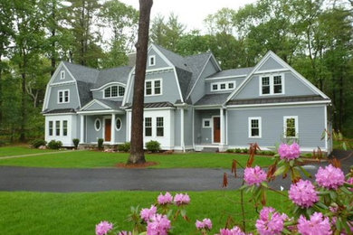 На фото: большой, двухэтажный, деревянный, серый дом в классическом стиле с мансардной крышей с
