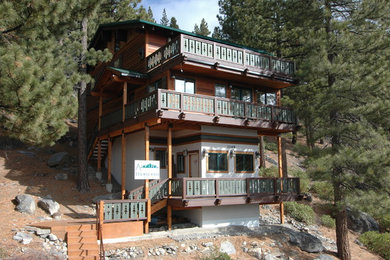 Example of a mid-sized mountain style brown three-story wood gable roof design in Other