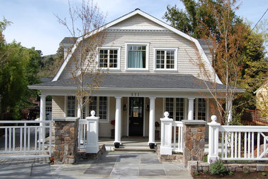 Modelo de fachada de casa beige de estilo de casa de campo de tamaño medio de dos plantas con revestimiento de madera, tejado a doble faldón y tejado de teja de madera