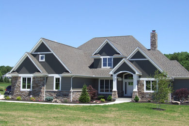 Foto de fachada de casa gris clásica de tamaño medio de dos plantas con revestimientos combinados y tejado de teja de barro