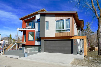 Trendy gray two-story stucco exterior home photo in Edmonton with a shed roof