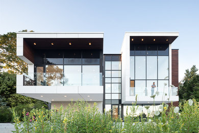 Modelo de fachada de casa blanca minimalista de dos plantas con revestimiento de aglomerado de cemento y tejado plano