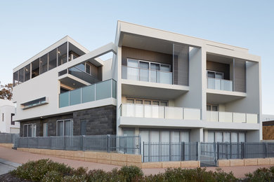Ejemplo de fachada de casa bifamiliar gris minimalista de tamaño medio de tres plantas con revestimiento de hormigón, tejado plano y tejado de metal