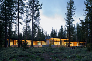 Стильный дизайн: большой, трехэтажный, серый частный загородный дом в современном стиле с облицовкой из камня, плоской крышей и металлической крышей - последний тренд