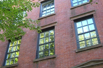 Imagen de fachada roja grande de tres plantas con revestimiento de ladrillo
