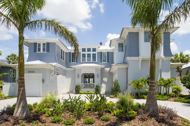 Large coastal blue two-story mixed siding house exterior idea in Tampa with a hip roof and a shingle roof