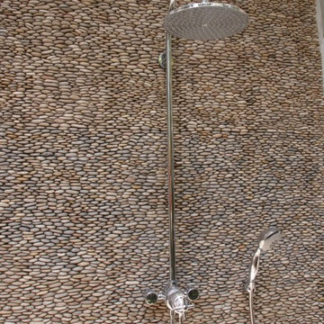 Tan Standing Pebble Tile Shower Wall