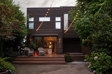 Imagen de fachada de casa marrón actual de tamaño medio de dos plantas con revestimiento de madera y tejado plano