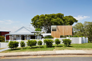 Immagine della facciata di una casa piccola bianca contemporanea a un piano con rivestimento in legno