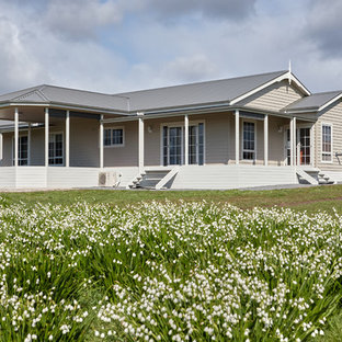 Photo of a traditional adobe beige house exterior in Other with a gable roof and a metal roof.